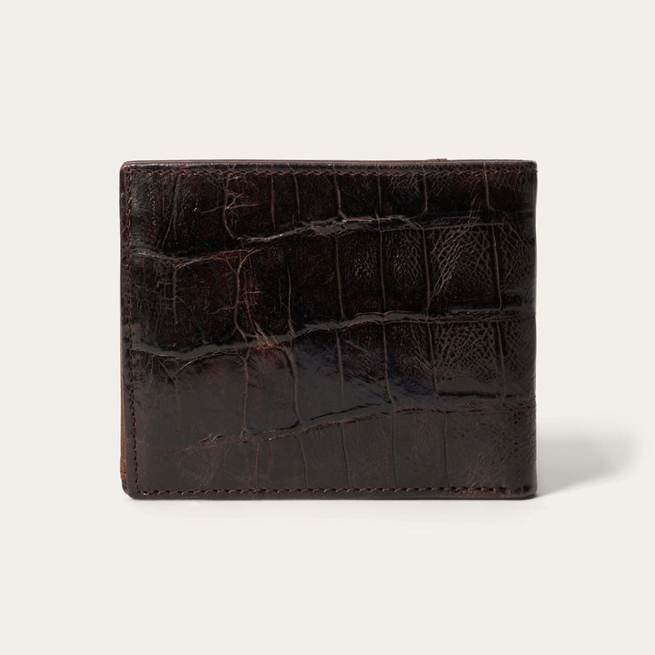 Made from top-grain leather, this bi-fold wallet features a brown embossed croco print and a tooled brown leather western overlay with an embossed Stetson logo. At once rugged and refined, each of our wallets embodies our legendary commitment to quality and attention to detail. 4.5" x 3.5" (115mm x 90mm) Leather Imported Classic Embossed Wallets For Formal Occasions, Vintage Brown Bifold Wallet With Coin Pocket, Formal Bifold Wallet With Embossed Details, Classic Embossed Bifold Wallets, Luxury Brown Trifold Wallet With Coin Pocket, Classic Embossed Leather Wallet, Brown Textured Leather Bifold Wallet, Brown Textured Leather Wallet, Formal Brown Wallet With Crocodile Pattern