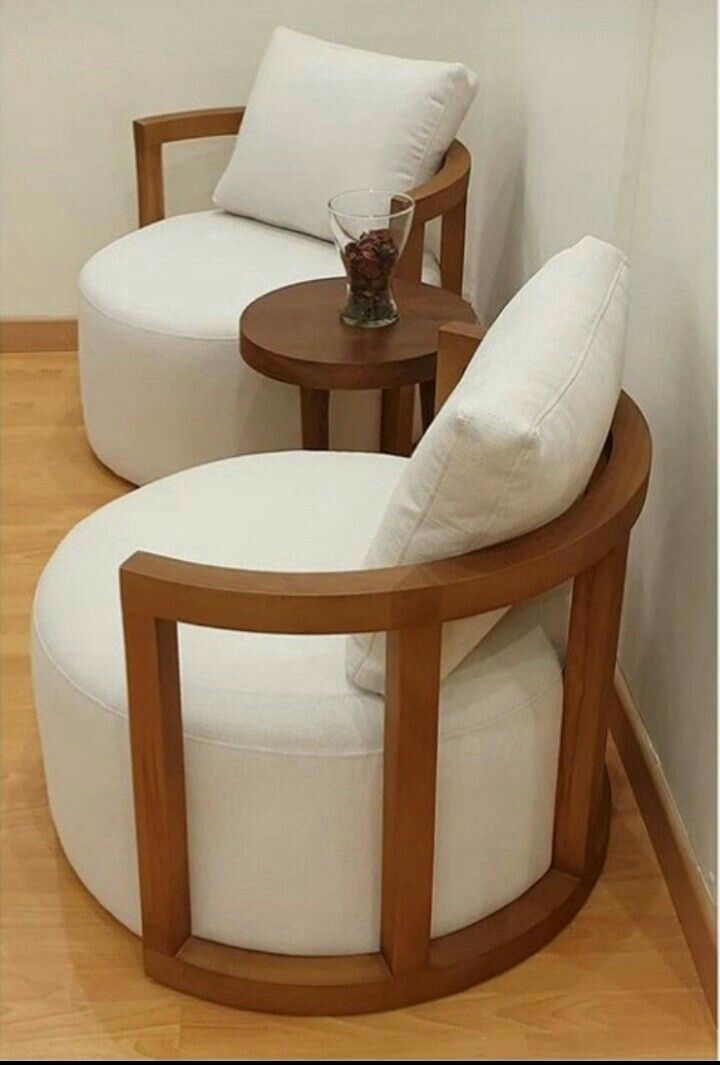 two white chairs sitting next to each other on top of a hard wood flooring