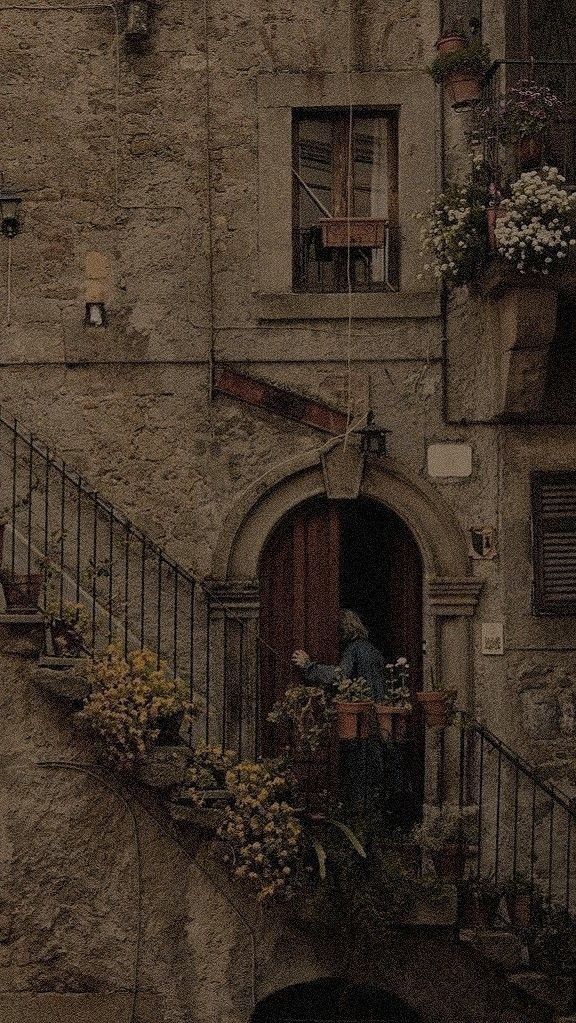 an old building with flowers on the balcony