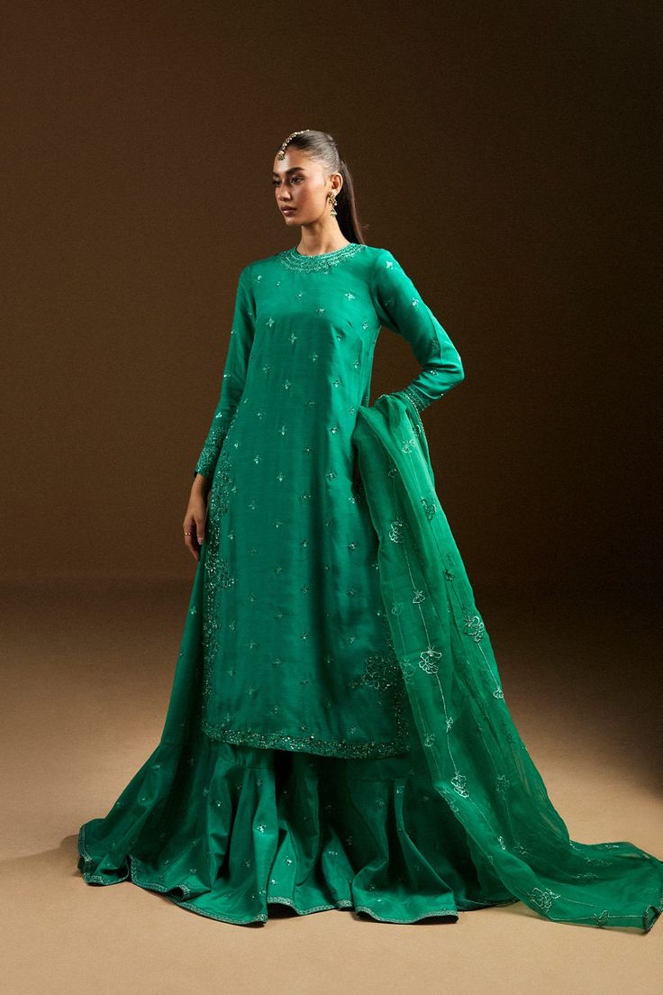 Aida Green Dola Silk Dress Shaped As Straight Kurta, Elegant Green Sharara With Gota Work, Designer Organza Sharara With Straight Kurta, Organza Sharara With Straight Kurta For Eid, Organza Sharara With Dabka On Straight Kurta, Sharara With Dabka Work And Straight Kurta In Organza, Green Chanderi Sharara For Party, Green Raw Silk Dress With Mirror Work, Green Dola Silk Unstitched Suit With Sheer Dupatta