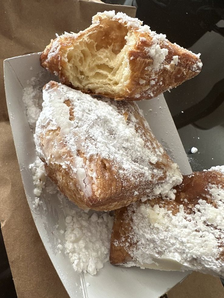 powdered sugar covered pastries are on a plate