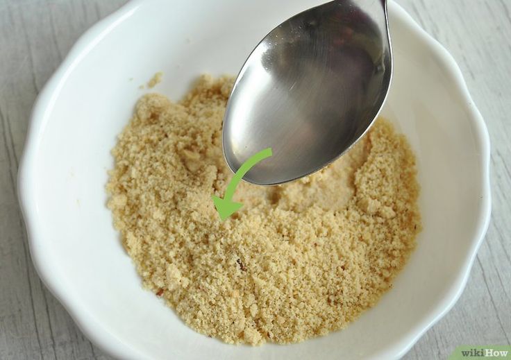 a white bowl filled with sand and a spoon