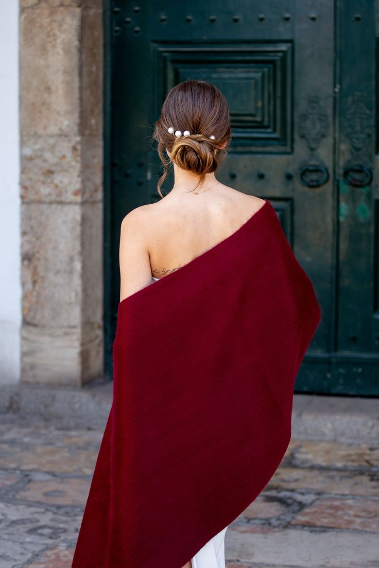 a woman wrapped in a red towel is walking down the street with her back to the camera