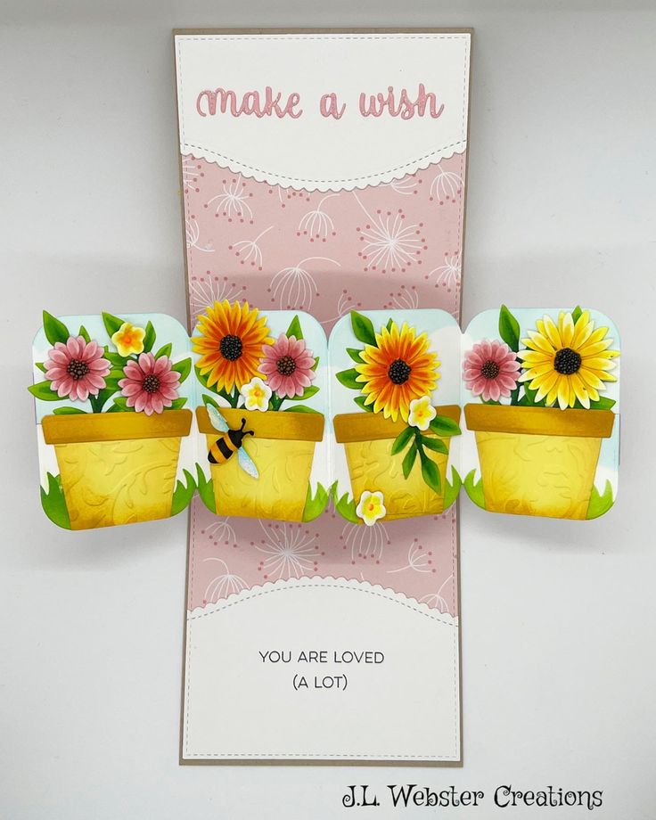 three sunflowers in flower pots on a card with the words make a wish