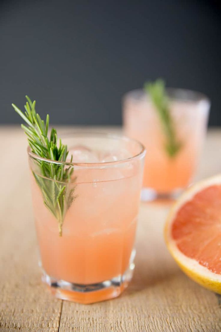 two glasses filled with grapefruit and rosemary garnish