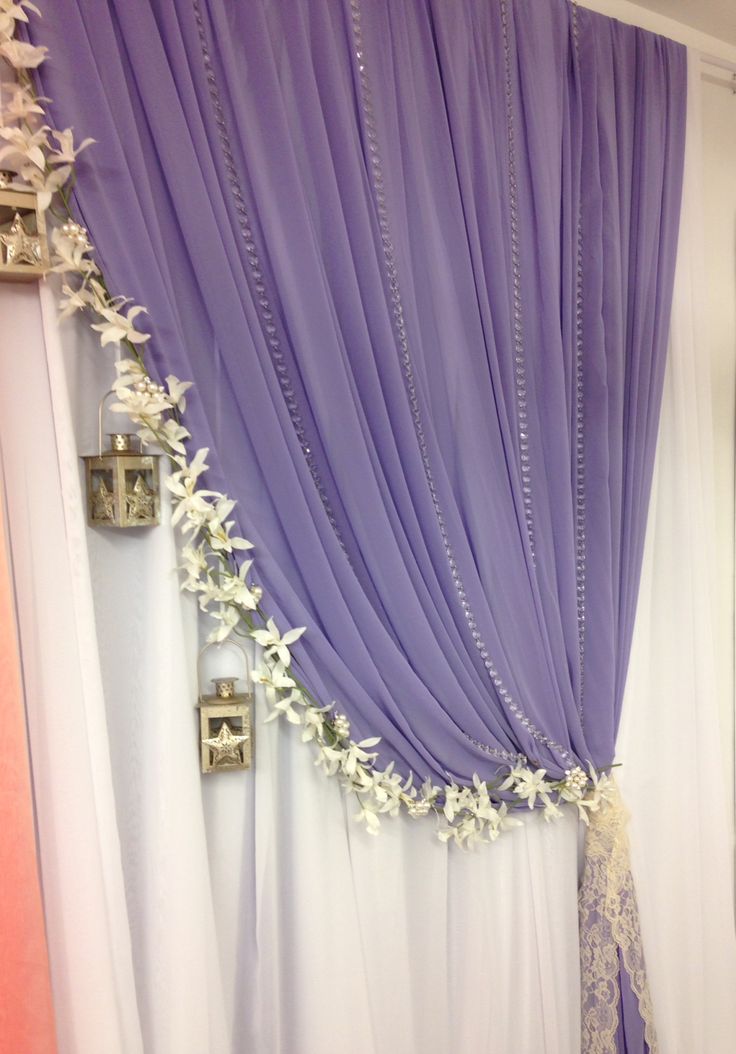 purple and white drapes are hanging on the wall