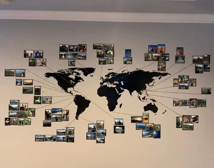 a wall with many pictures on it and a world map hanging from the middle one