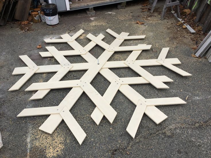 a wooden snowflake sitting on the ground