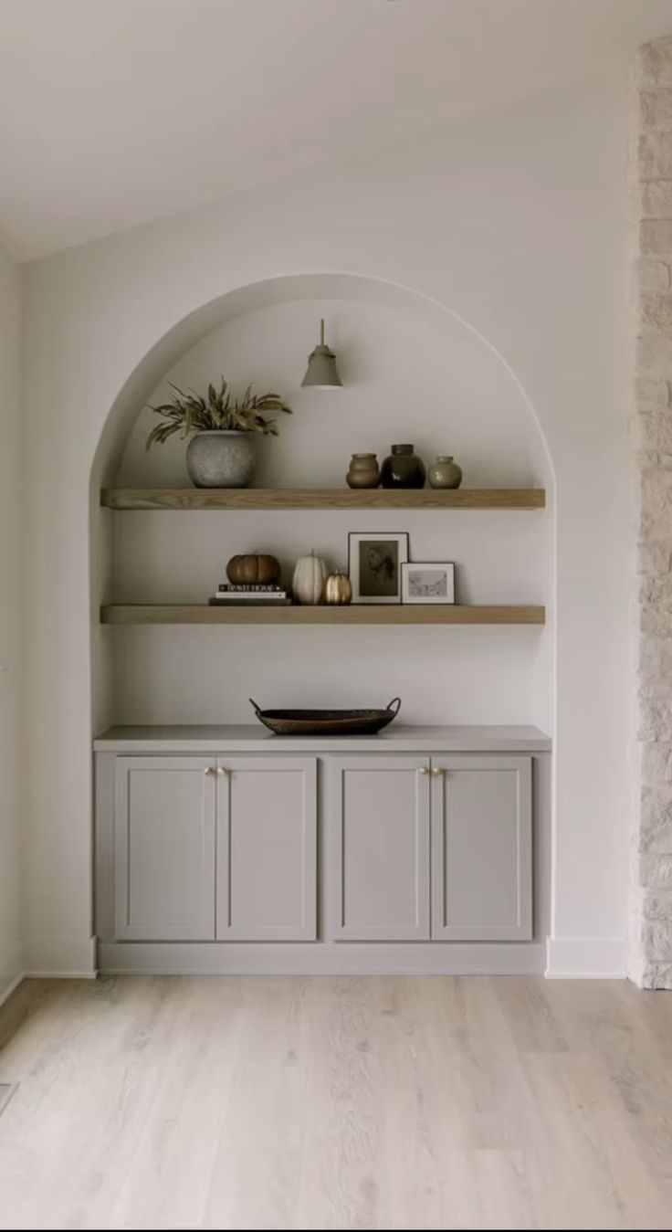 an image of a room with shelves and pictures on the wall above it, along with other items