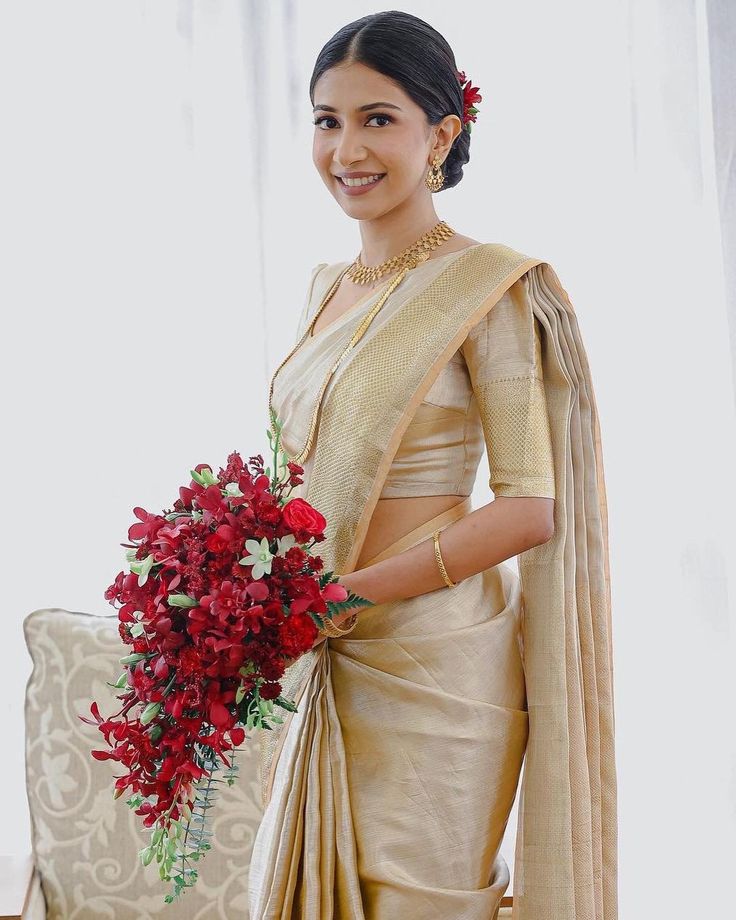 a woman in a sari holding a bouquet of flowers