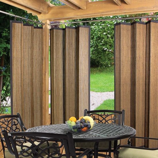 an outdoor dining area with patio furniture and curtains