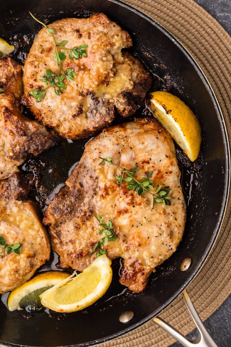 some meat and lemons are cooking in a skillet