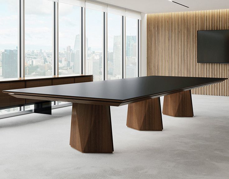 a conference table in an office with large windows and cityscape on the wall