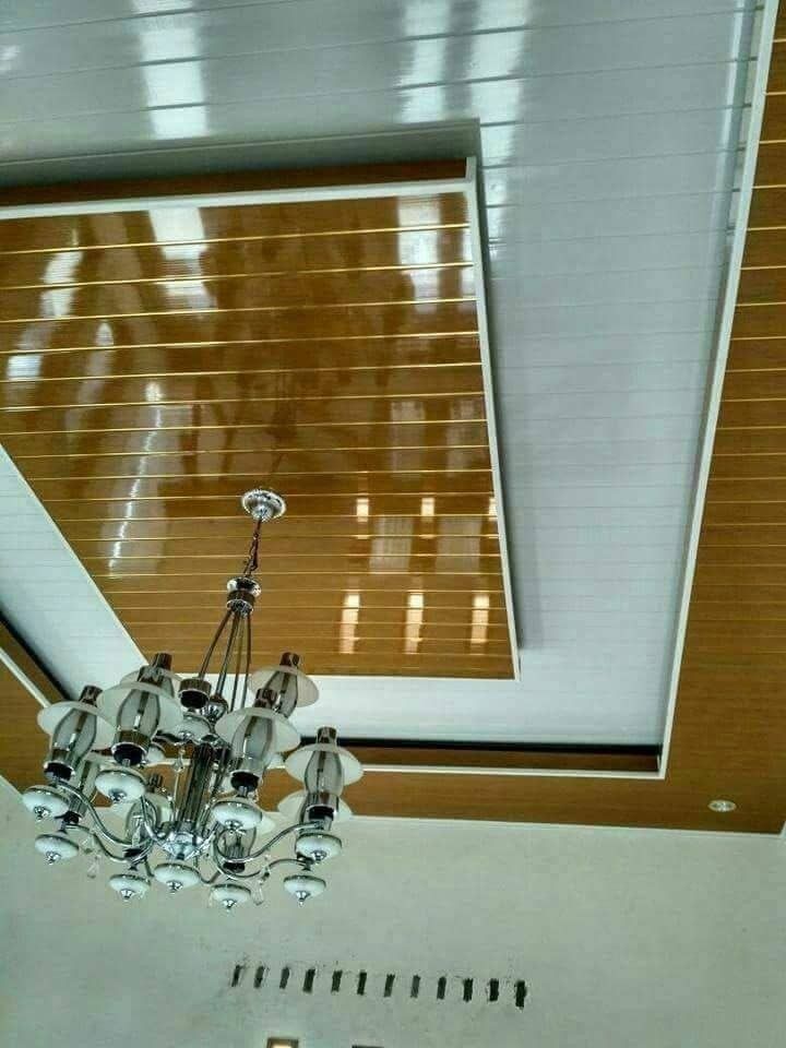 a chandelier hanging from the ceiling in a room with wood paneled ceilings