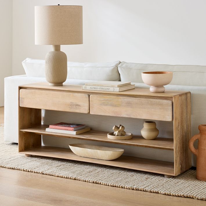 a living room scene with focus on the coffee table and vases in front of the couch