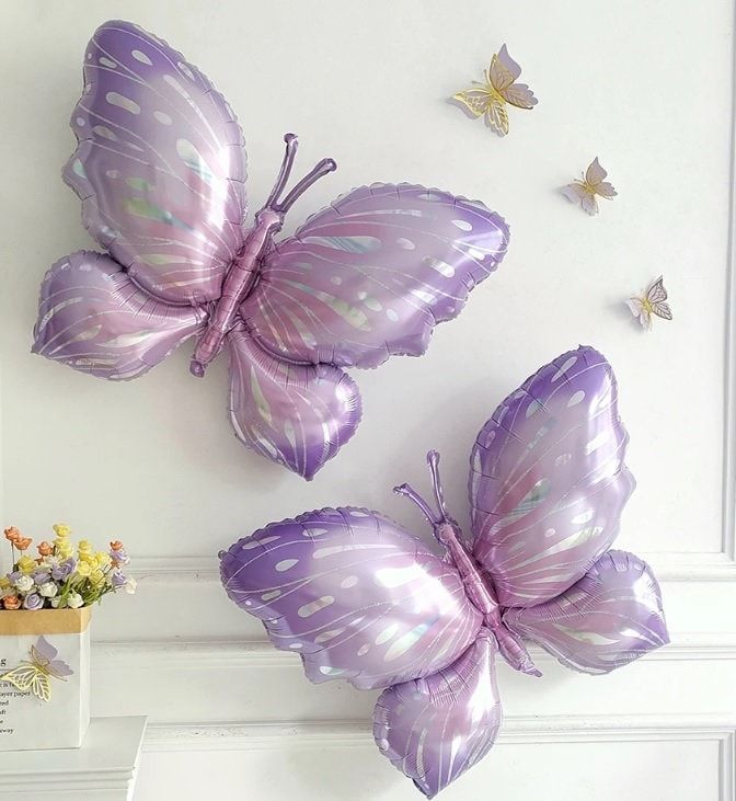 two purple butterflies are hanging on the wall