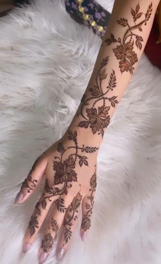 a woman's hand with henna tattoos on it