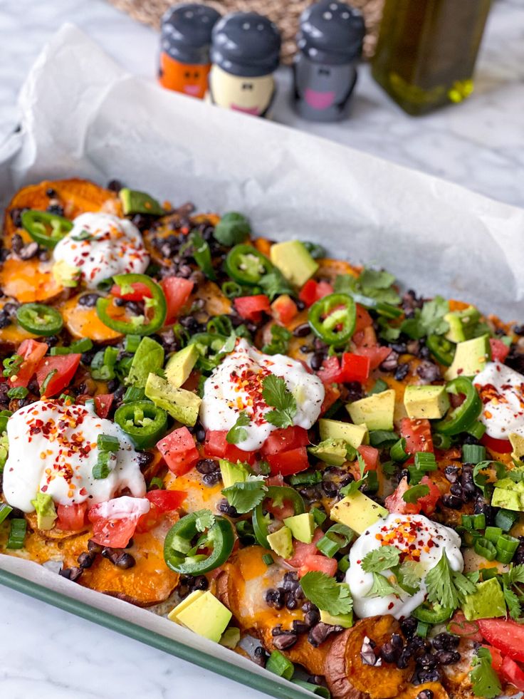 an enchilada casserole with tomatoes, black beans, avocado and sour cream