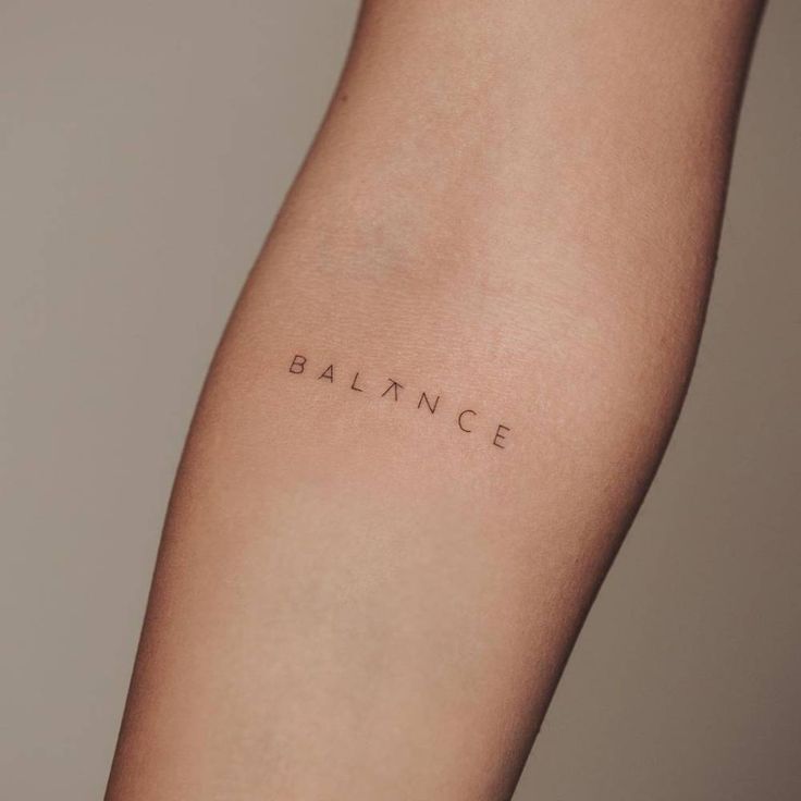 a woman's arm with the word balance tattooed on her left side, in cursive font