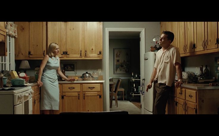 a man and woman standing in a kitchen