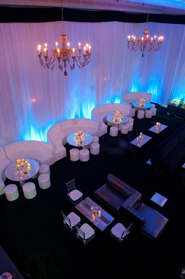 an overhead view of a banquet room with round tables and white couches set up