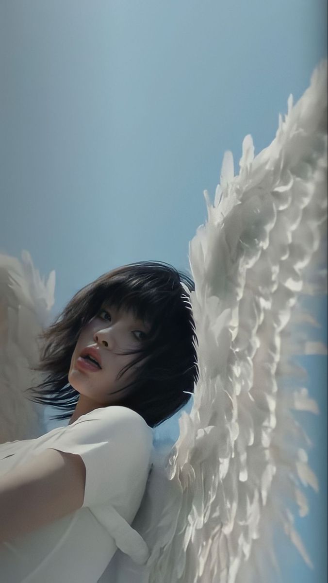 an angel with white wings is posing for the camera