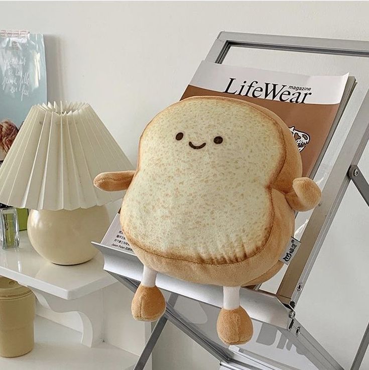 a stuffed toy sitting on top of a table next to a lamp and magazine rack