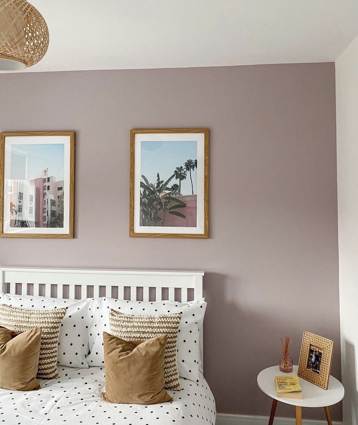 a bedroom with two pictures hanging on the wall