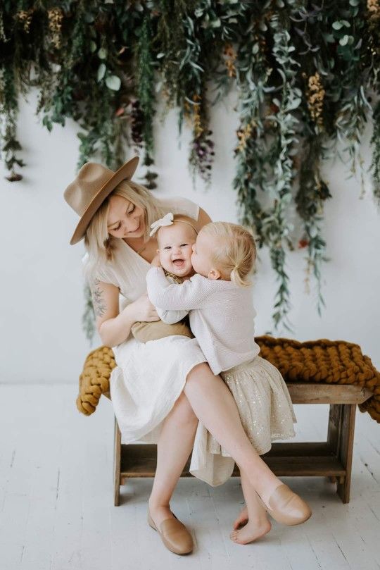 two women and a baby are sitting on a bench