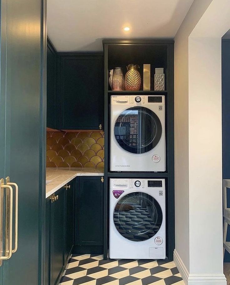 a washer and dryer in a small room with black cabinets on the wall