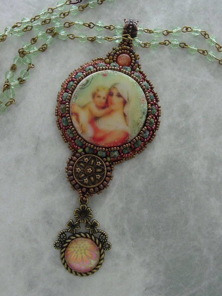 Beautiful Mother and child made from wood and sealed to perfection. Surround by beads, and adorned with a Sun stone on top ,and a vintage button below. This necklace has the feel of a rosary, with a glass cabochon hanging from the bottom This pendant measures 4 inches long x 1 1/2 inches wide, and hangs from a 36 inch crystal chain, that can be wrapped around the neck twice for a shorter look, or hang long. Vintage Beads And Cabochons For Jewelry Making, Vintage Round Beads For Jewelry Making, Vintage Necklaces With Oval Beads For Gift, Handmade Vintage Pendant Beaded Necklaces, Antique Handmade Beads Gems And Cabochons For Gift, Vintage Beaded Medallion Jewelry, Vintage Handmade Beaded Necklaces As Gift, Vintage Oval Beads Necklaces For Gift, Handmade Vintage Pendant Beaded Necklace