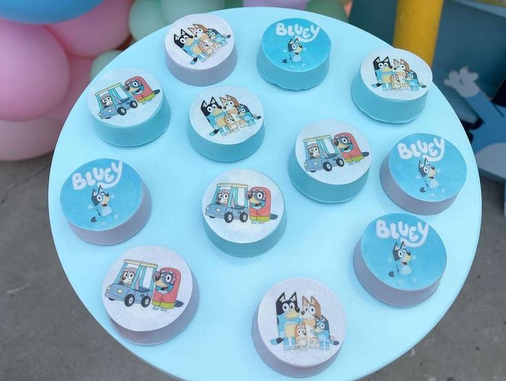 there are many small cupcakes on the cake plate that is decorated with cartoon characters