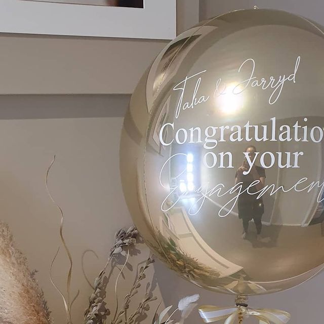 there is a large balloon with the words congratulations on it next to flowers and a teddy bear