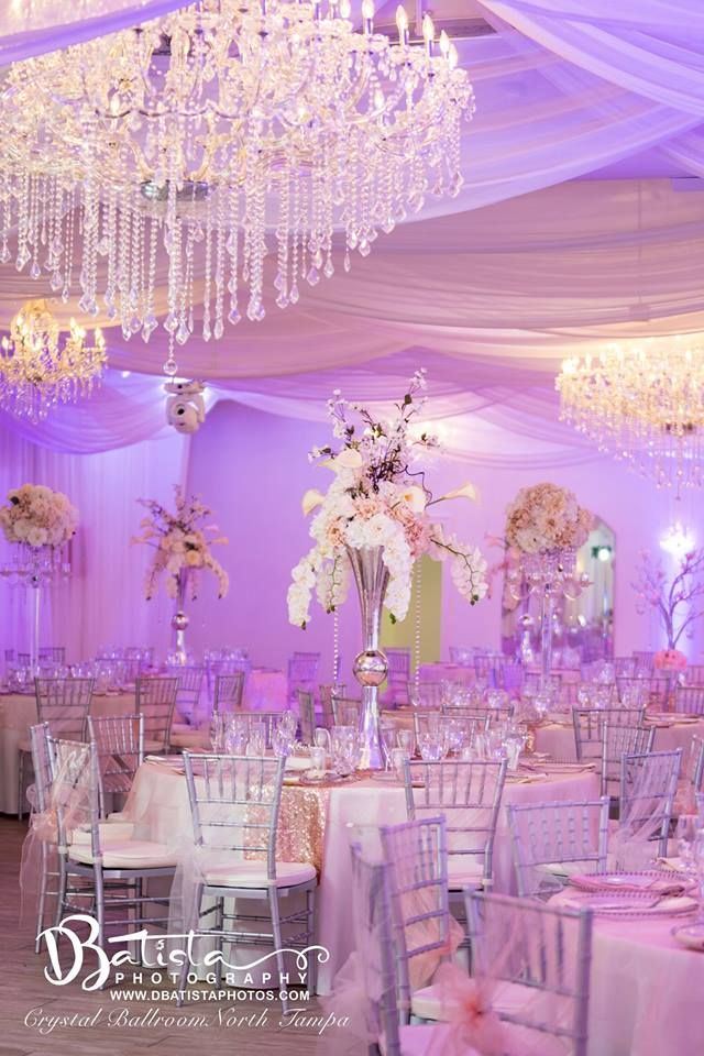 an elegant wedding reception with chandeliers and white tablecloths on the tables