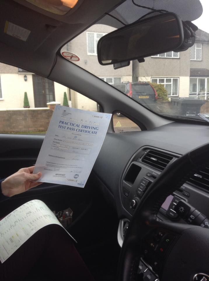 a person driving a car with a paper in their hand