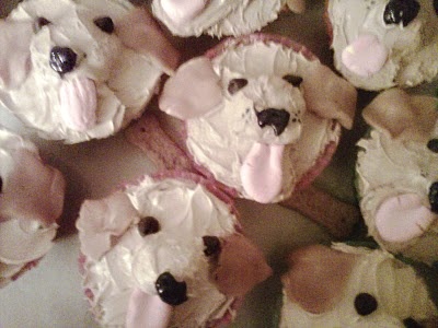 several cupcakes with white frosting and black dots are arranged in the shape of dogs