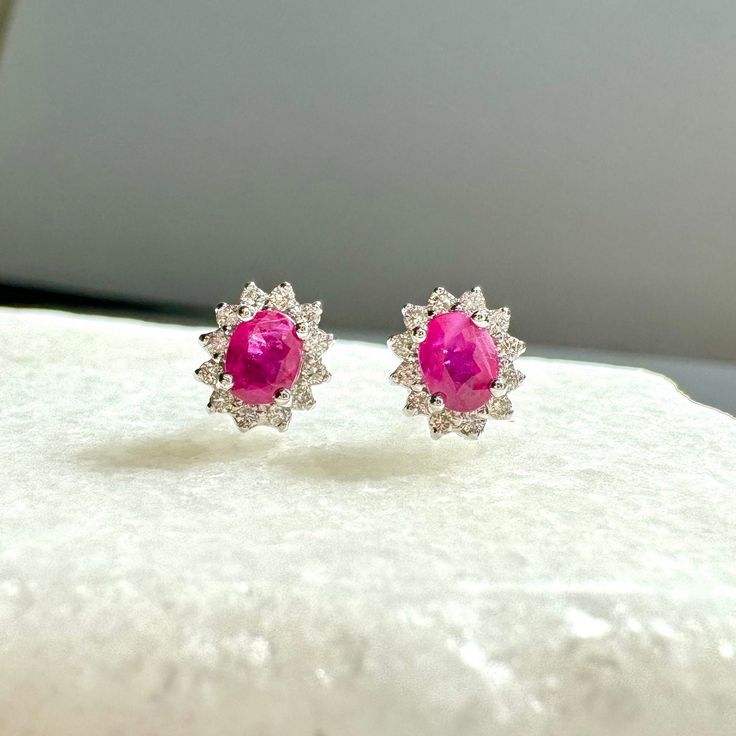 A timeless and classic design, symbolizing love, commitment and wealth. Perfect for everyday wear or dressed up for special occasions. Rubies are said to symbolize the sun, while its glowing hue suggests an inextinguishable flame within the stone. Add a pop of color with our Genuine Ruby and Diamond Solaris Earrings, available in 14k solid white gold and 14k solid yellow gold. Item Specifications: Materials: 14k Solid Gold  Gemstone: Natural Ruby Earring Diameter: 7.5 mm x 6.6 mm Ruby Diameter: Elegant Ruby Earrings With Brilliant Cut, Luxury Ruby Jewelry With Halo Design, White Gold Gemstone Round Earrings, Elegant Round Ruby Diamond Earrings, White Gold Earrings With Gemstones, White Gold Ruby Earrings With Halo Design, Formal Round Cut Gemstone Diamond Earrings, Elegant Silver Ruby Diamond Earrings, Luxury Ruby Earrings With Halo Design