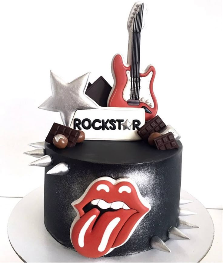 the rolling stones cake is decorated with guitar, stars, and lipstick on it's side