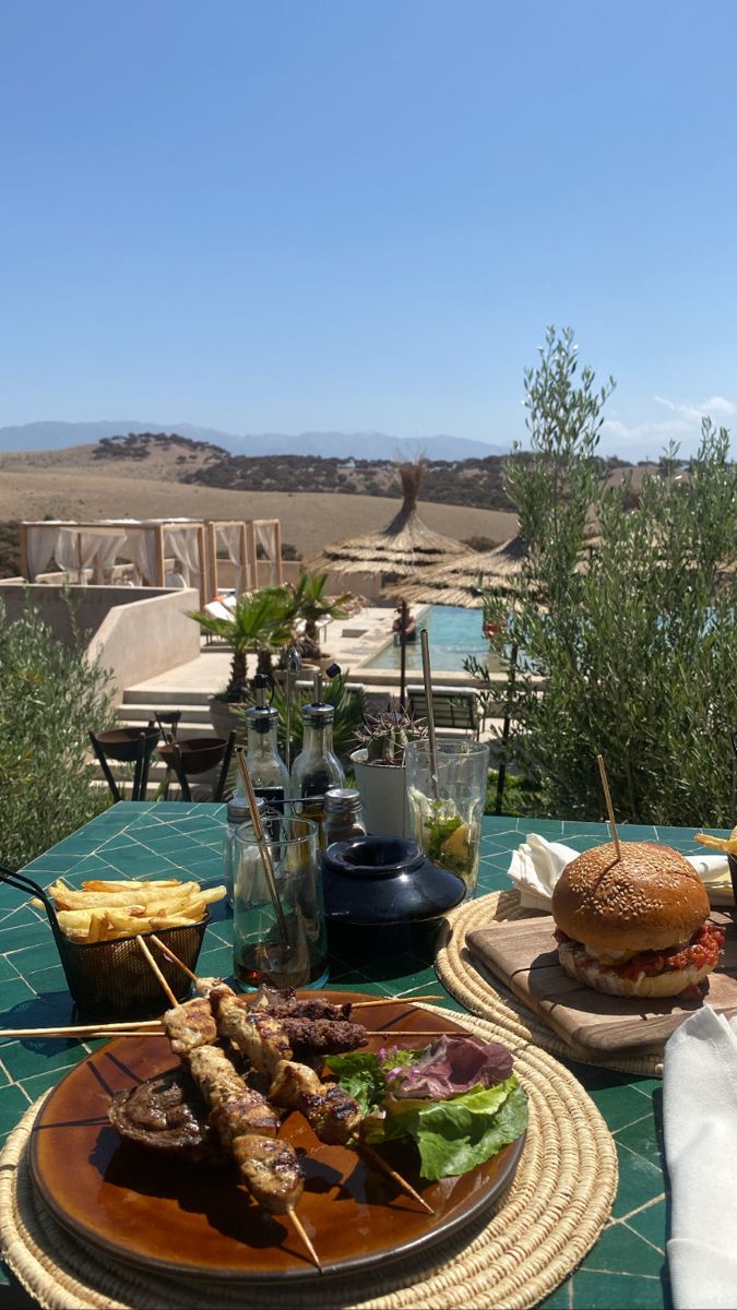 an outdoor table with food and drinks on it