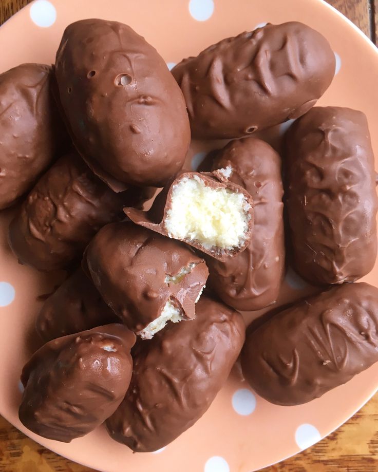 chocolate covered donuts on a pink plate with white polka dots