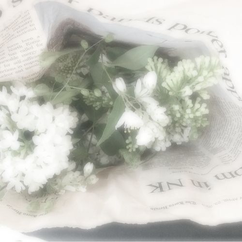 some white flowers are sitting on top of an old newspaper