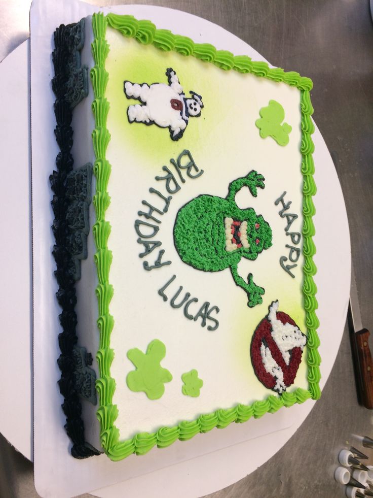 a birthday cake with green frosting on a white plate