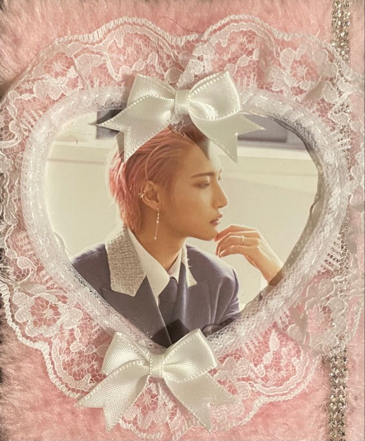 a woman with pink hair wearing a white bow in a heart - shaped photo frame