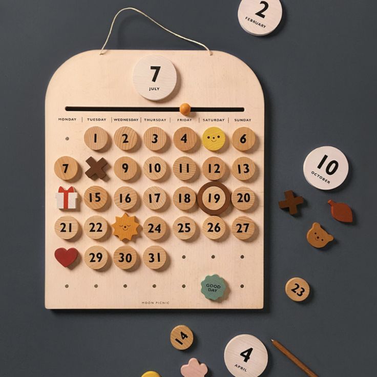 a wooden calendar with buttons and numbers on it