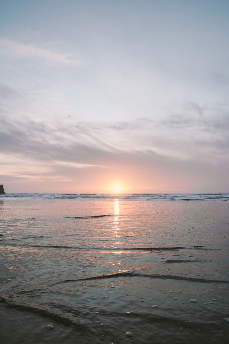 the sun is setting over the ocean with waves