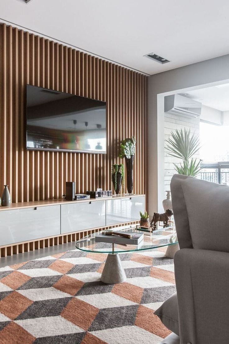 a living room with a couch, coffee table and television on top of the entertainment center