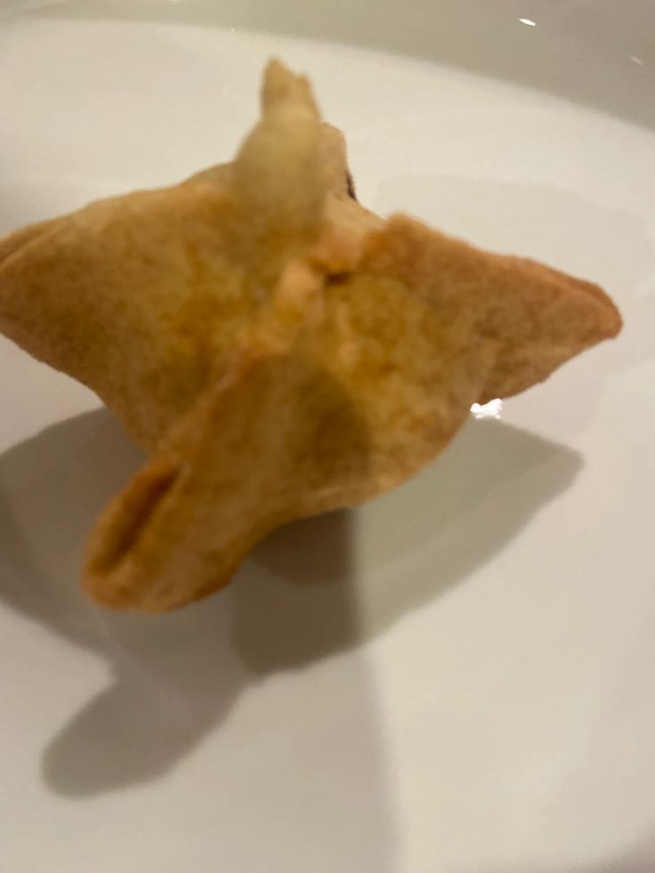 a small piece of food sitting on top of a white plate