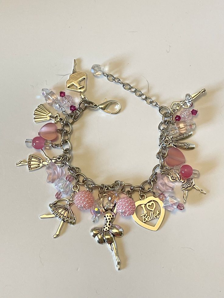 a bracelet with charms on it that include an angel, heart, cross and other items