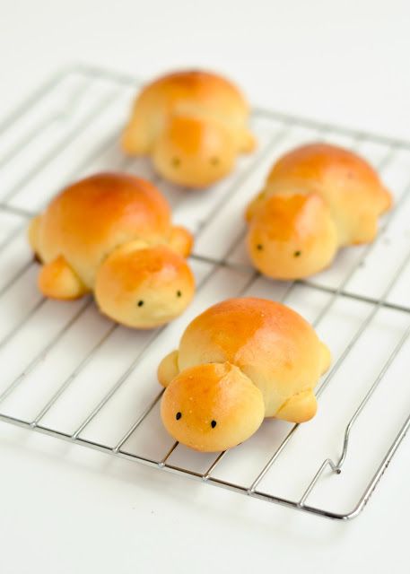 four buns shaped like animals sitting on a cooling rack