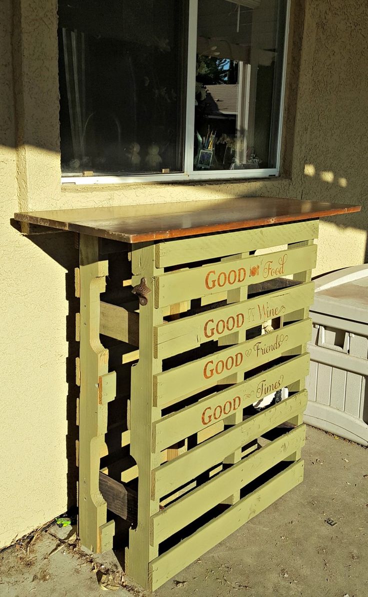 a wooden pallet with words written on it sitting in front of a window sill